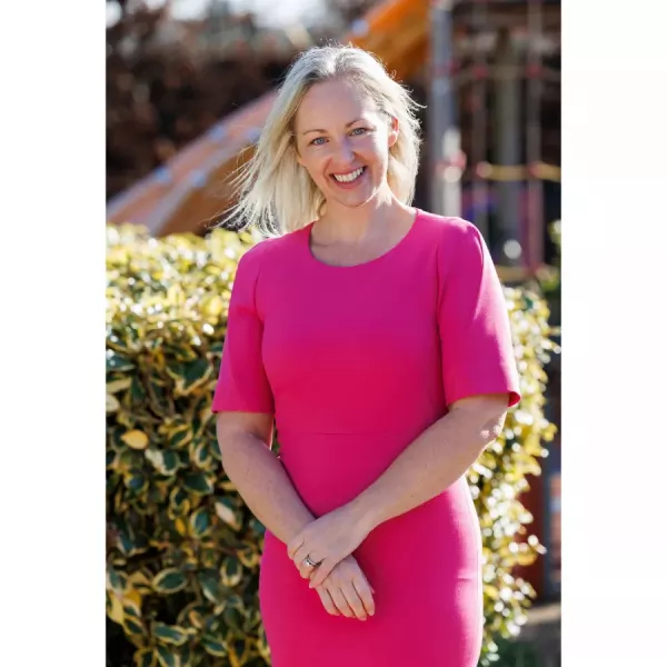 CEO Kerry McLaverty wearing a pink dress standing outside 