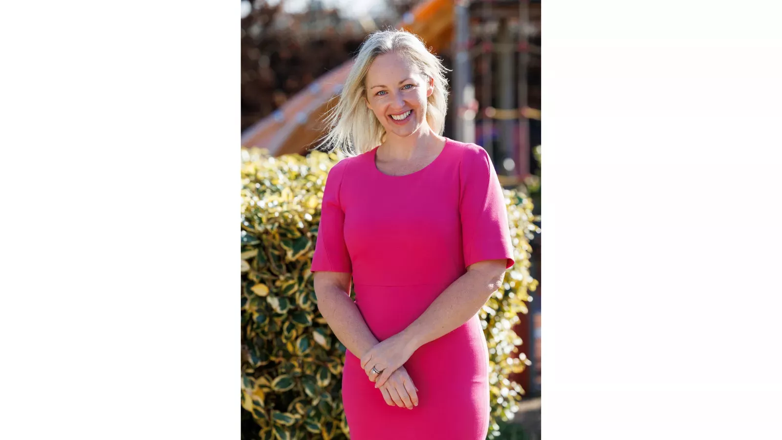 CEO Kerry McLaverty wearing a pink dress standing outside 